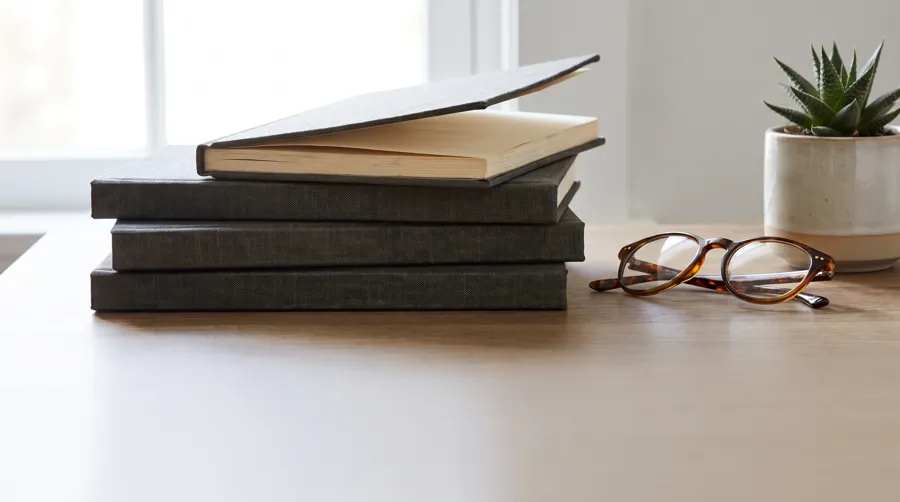 Stack of personal journals on a bookshelf representing years of gratitude journaling practice