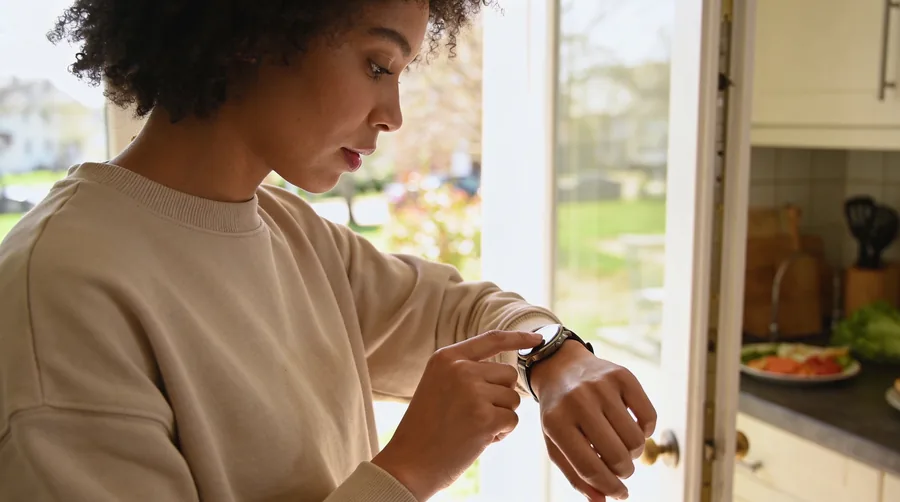 person checking the time on a watch before setting out for a short walk after a meal
